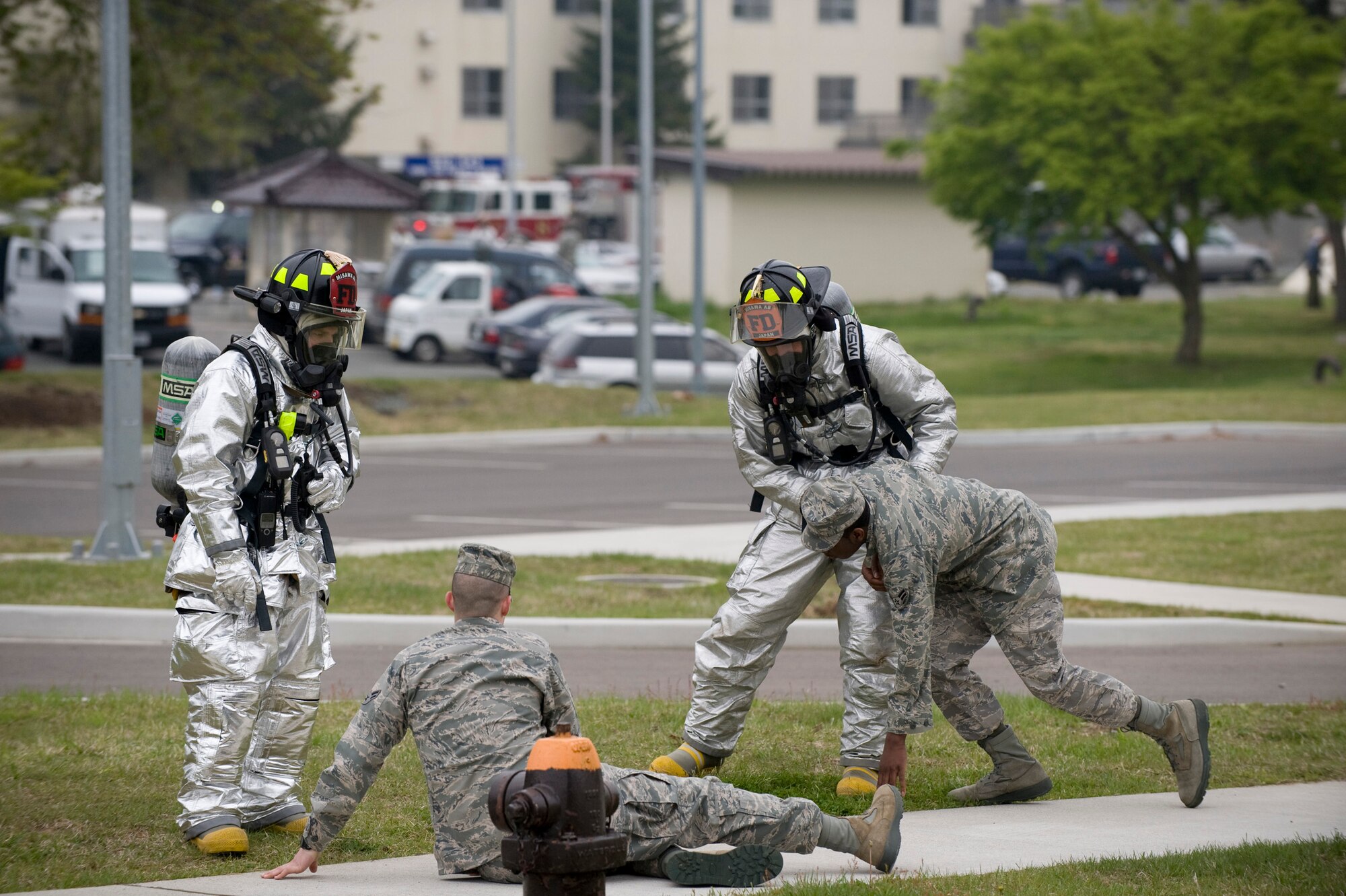 MISAWA AIR BASE, Japan -- Staff Sgt. Joseph Funck and Senior Airman David Dunn, 35th Civil Engineer Squadron firefighters, assist two simulated blast victims out of a cordon area during an emergency management exercise at the Richard Bong Theater May 19. The 35th Civil Engineer Squadron, 35th Security Forces Squadron, 35th Aerospace Medical Squadron and several other units converged on the theater to test their units' preparedness. (U.S. Air Force photo/Staff Sgt. Samuel Morse)