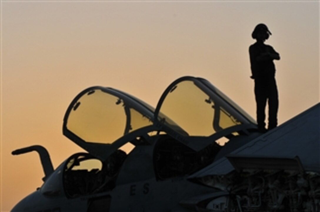 A U.S. Navy sailor from Electronic Attack Squadron 140 enjoys the sunset while standing on top of an EA-6B Prowler aircraft aboard the aircraft carrier USS Dwight D. Eisenhower (CVN 69) in the north Arabian Sea on May 14, 2010.  The Eisenhower Carrier Strike Group is deployed as part of an ongoing rotation of forward-deployed forces in the U.S. 5th Fleet area of responsibility.  