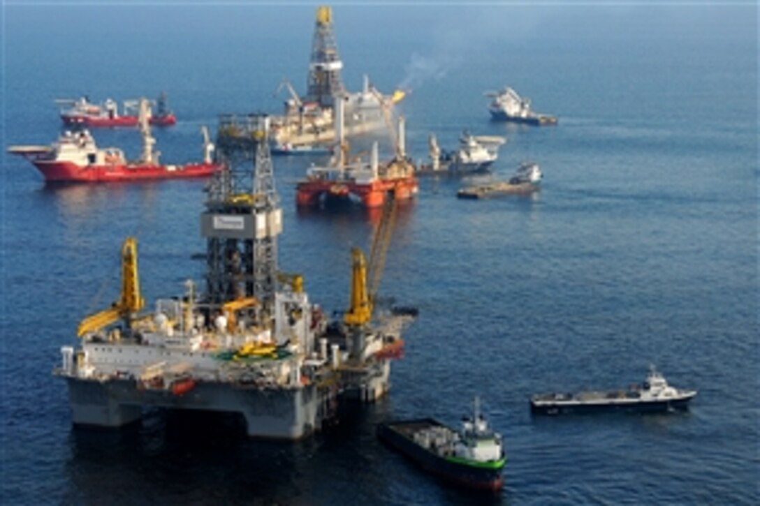 From foreground, the mobile offshore drilling unit Development Driller II prepares to drill a relief well at the site of the Deepwater Horizon oil spill, May 18, 2010, as the Modular Drilling Unit  Q4000 holds position directly over a damaged blowout preventer and the drillship Discover Enterprise continues to capture oil from the ruptured riser.