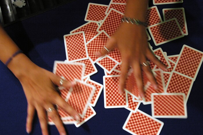 Melissa Rauschenberg, a dealer with Casino Gold, mixes the cards in front of her players prior to shuffling and dealing them at the Texas Hold ‘em No Limits Championship Tournament at the recreation center, May 21.