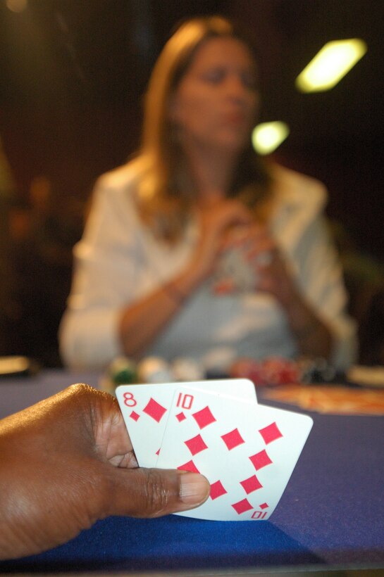 Dennis Davis, recreation aid at the Fitness Center and winner of the first preliminary tournament checks his cards as he waits for his fellow player to make their bets at the Texas Hold ‘em No Limits Championship Tournament at the recreation center, May 21.