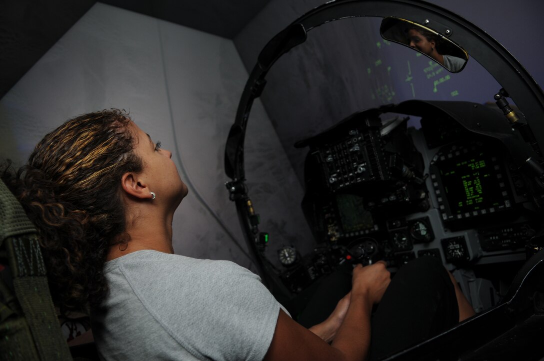 Doorly Winegar, Marine Attack Squadron 211 spouse, tests out her aviation skills in the AV-8B Harrier flight simulator at the Marine Corps Air Station in Yuma, Ariz., during VMA-211’s Jane Wayne Day May 21, 2010. More than 20 spouses spent the day touring the station and experiencing some of what it takes to be a Marine. “I just thought we’d get a tour of the base,” said Winegar. “It makes me appreciate what the other Marines do.”