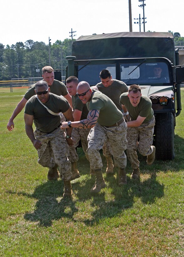 Marines with II Marine Expeditionary Force Headquarters Group strain to pull a humvee during a II MHG field meet aboard Camp Lejeune, N.C., May 21, 2010. The field meet not only gave the Marines a fun way to relax, but also aided in building unit camaraderie.