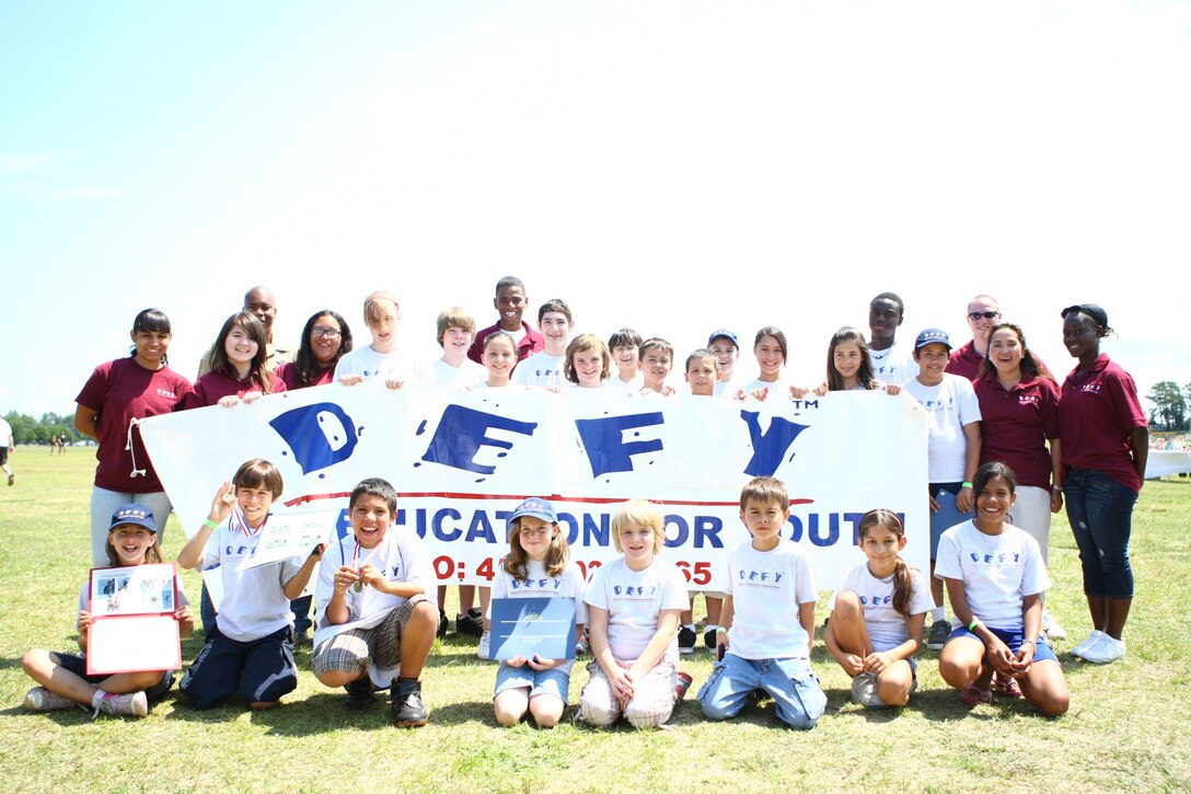 Phase II graduates of the Drug Education for Youth Program as well as several mentors and junior mentors took a moment to pose for a photo after their graduation ceremony during Maynia on W.P.T. Hill field, May 22. Some of the new graduates will even come back next year as junior mentors to help future participants master positive social skills, better resolve conflicts and stay healthy and drug free.