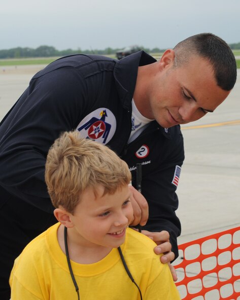 Staff Sgt. Christopher Mason, United States Air Force Thunderbirds, signs a fan's t-shirt at the Thunder Over the Red River Air Show at Grand Forks Air Force Base, N.D. May 22. The Air Show, which was highlighted by the United States Air Force Thunderbird Aerial Demonstration Team, was the first to be held at Grand Forks AFB since 2006 and had more than 31,000 spectators. (U.S. Air Force photo by Airman 1st Class Amber Price)