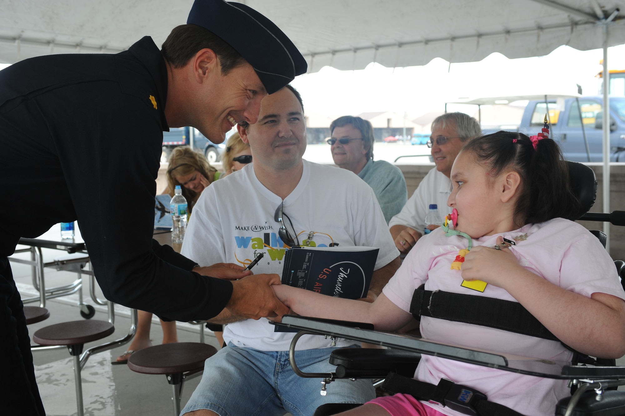 Maj. Sean Gustafson, United States Air Force Thunderbirds, greets Megan and her family during Make-A-Wish Day at Grand Forks Air Force Base May 21. The Make-A-Wish foundation of North Dakota provides opportunities for children with life-threatening medical conditions to help the human experience with hope, strength and joy. (U.S. Air Force photo by Airman 1st Class Amber Price)