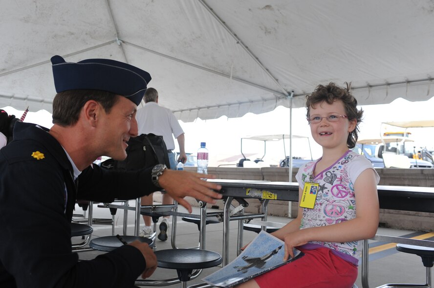 Maj. Sean Gustafson, United States Air Force Thunderbirds, explains a flight manuever with Ellen during Make-A-Wish Day at Grand Forks Air Force Base May 21. The Make-A-Wish foundation of North Dakota provides opportunities for children with life-threatening medical conditions to help the human experience with hope, strength and joy. (U.S. Air Force photo by Airman 1st Class Amber Price)