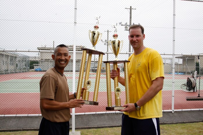 Simeon Cadavos, leading chief with 11th Dental Co., and Chief Petty Officer Ron Hunter, in-coming leading chief with 11th Dental Co, take home first and second place trophies during the Spring Tennis Tournament at the tennis courts here May 22.