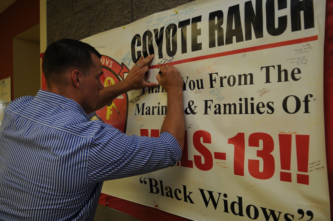 Cpl. Dylan Cox, Marine Aviation Logistics Squadron 13 aircraft maintenance support technician, signs a poster May 22, 2010, thanking the residents of Coyote Ranch in Yuma, Ariz., for supporting MALS-13. For the past four years, the residents of Coyote Ranch, a retirement community, have supported MALS-13 with care packages and social events. The local retirees cooked the Marines a celebratory dinner, an event which for some Marines was the first time they met the people behind packages.
