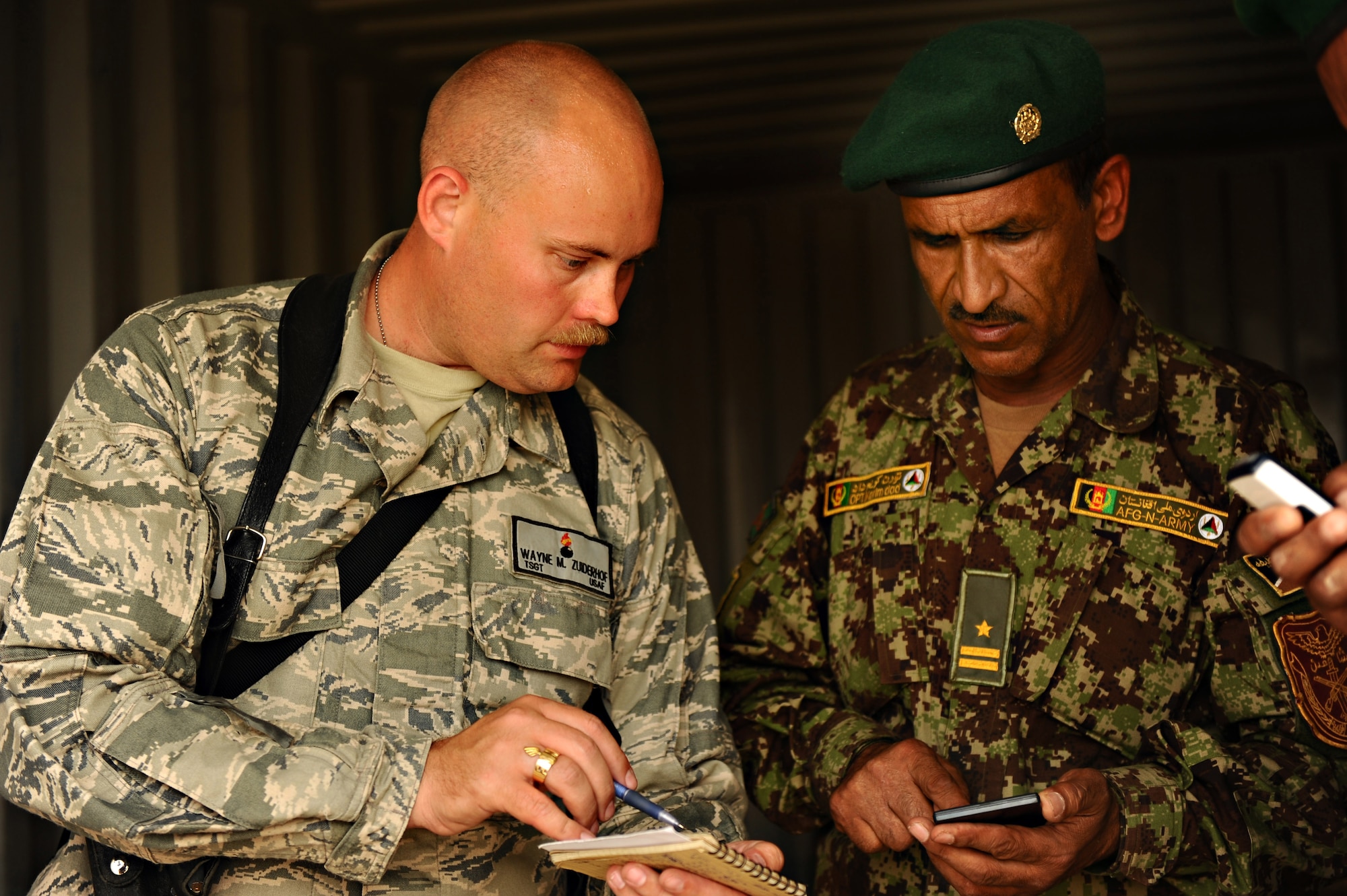MAZAR-E-SHARIF, Afghanistan – Tech. Sgt. Wayne Zuiderhof, munitions platoon mentor, verifies munitions quantities with a customer at the Camp Shaheen Ammunition Supply Point. (U.S. Air Force photo/Master Sgt. Christopher DeWitt)