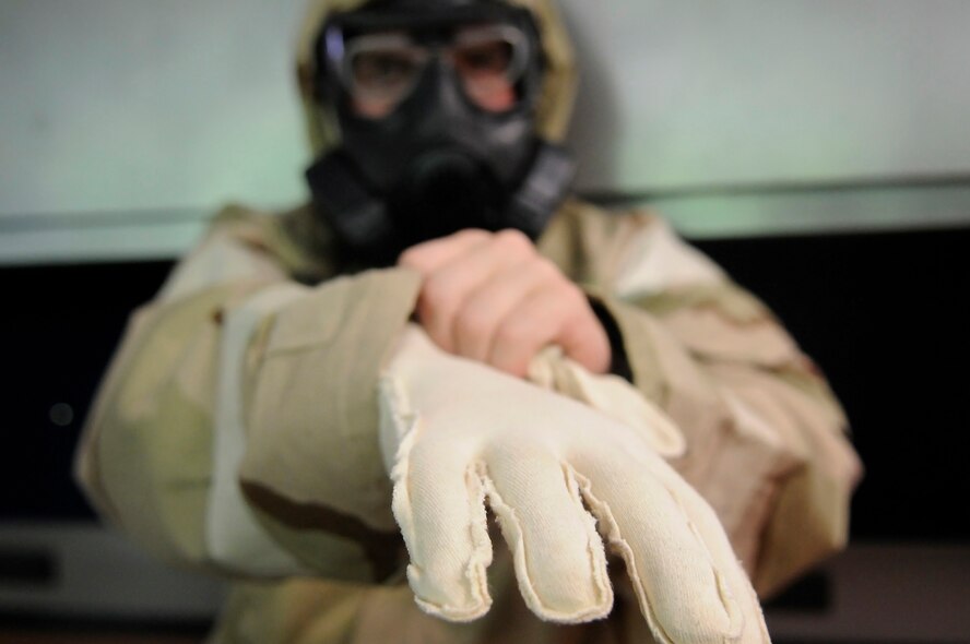 U.S. Air Force Airman 1st Class Michael Poffenberger, 886th Civil Engineering Squadron explosive ordnance disposal apprentice, dons personal protective attire during an Operational Readiness Exercise, Ramstein Air Base, Germany, May 23, 2010. OREs are conducted to evaluate mission readiness and the ability to survive and operate in a chemical environment. (U.S. Air Force photo by Airman 1st Class Desiree Esposito)