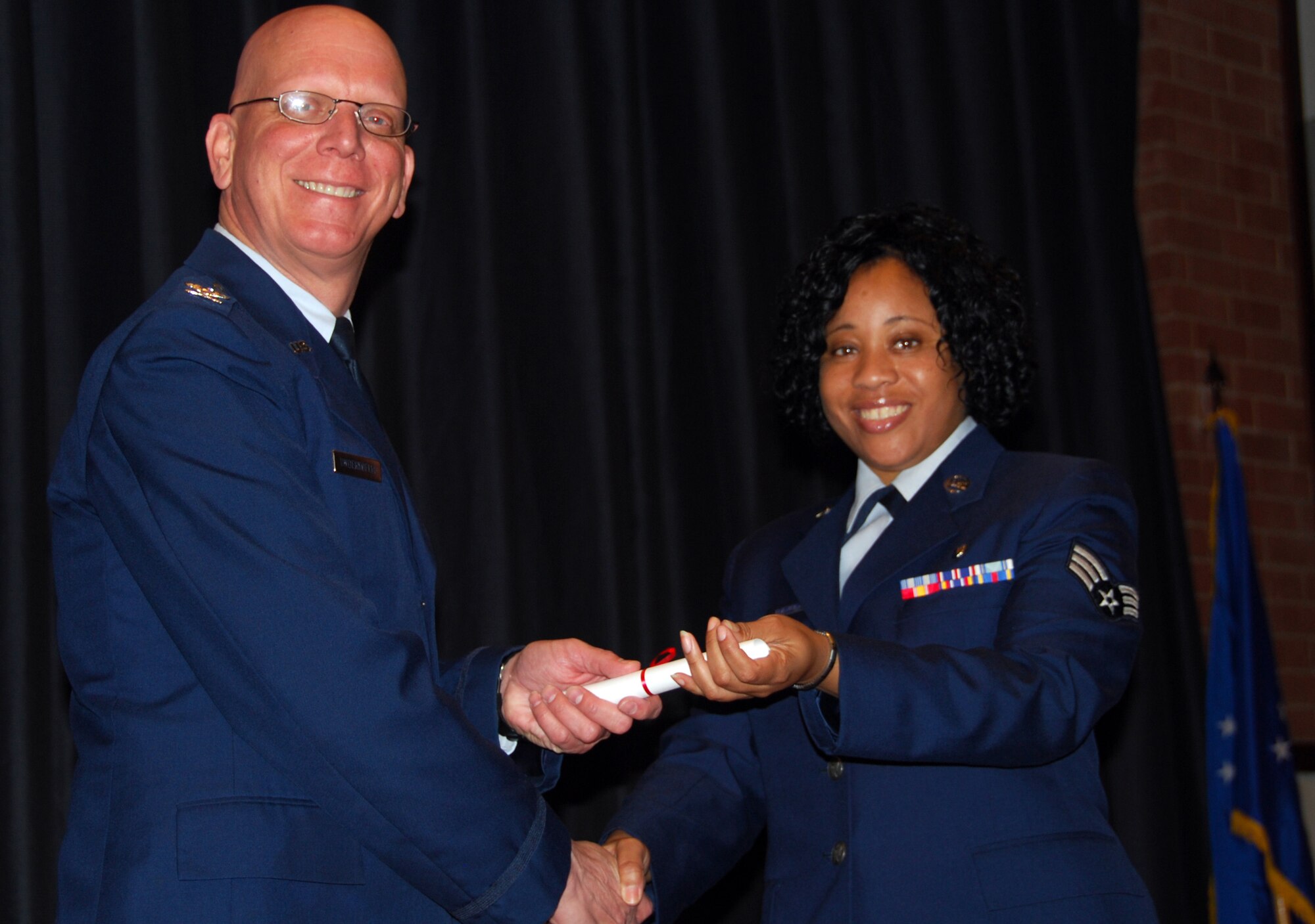 JOINT BASE MCGUIRE-DIX-LAKEHURST, N.J. - Col. Michael B. Underkofler, vice commander, presents Senior Airman Carleen Prescod with a diploma for her Community College of the Air Force Applied Science degree in Cardiopulmonary Laboratory Technology, May 2 during graduation ceremonies held at the Expeditionary Center here. Thirty 514th Air Mobility Wing members have completed requirements to receive a CCAF associate degree in their respective fields for the spring 2010 class. (U.S. Air Force photo/Master Sgt. Donna T. Jeffries)