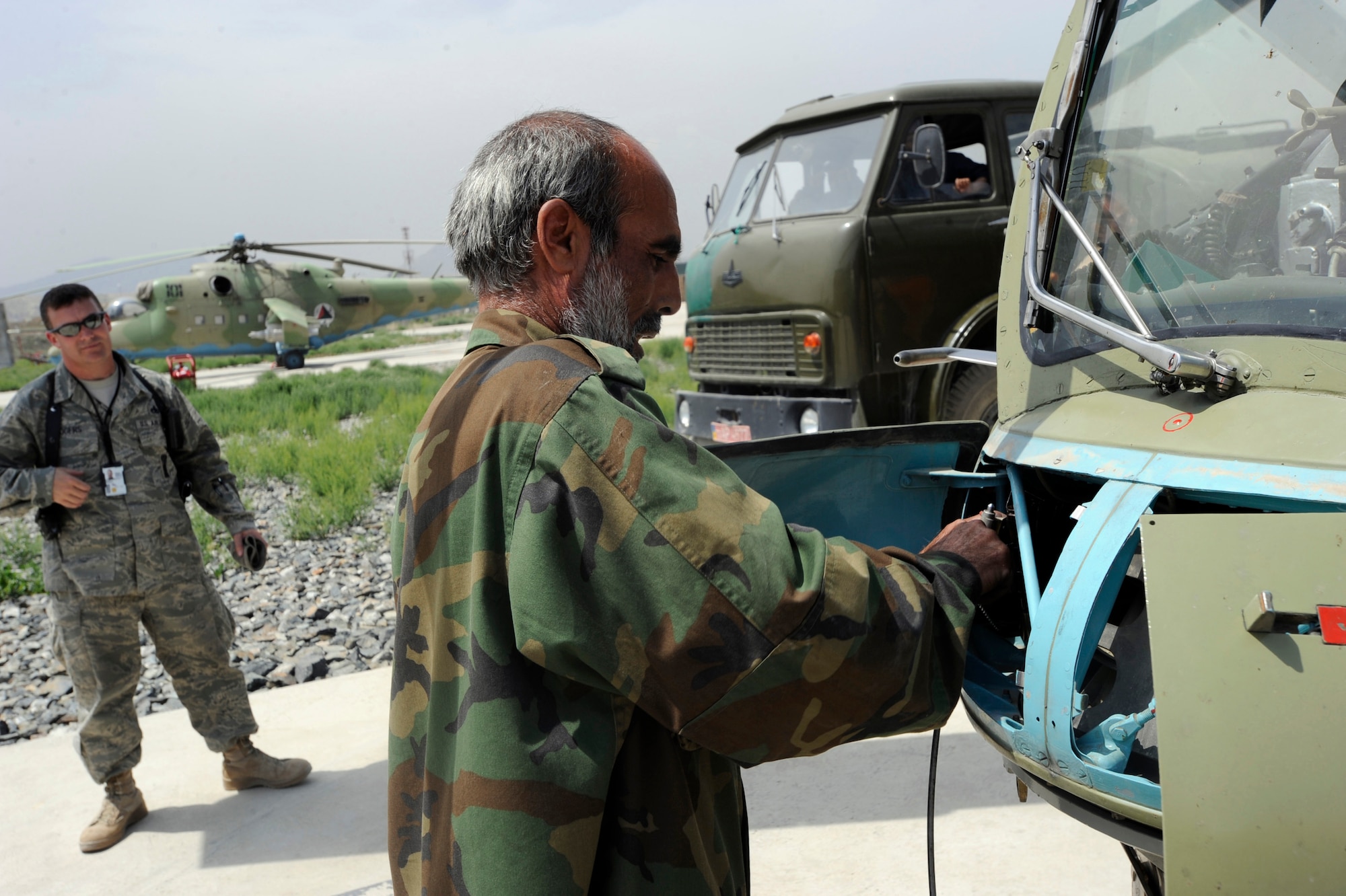 Master Sgt. Raymond Rogers Jr., 438th Air Expeditionary Advisory Squadron armament and ammunition flight advisor, watches as Lt. Amin Ullah, Aghanistan National Army Air Coprs weapons loader, cleans out the bullet chamber of a Yak-B Gatling gun on an MI-35 Hind E attack helicopter after a training mission May 15, 2010, at Kabul International Airport, Afghanistan. ?When I first got here we had nine Afghans assigned to us and they had no knowledge of how to execute this mission,? said Sergeant Rogers, who is deployed from Seymour -Johnson Air Force Base, N.C. ?To see these guys go from knowing nothing about loading weapons on these airframes to conducting the mission with me just standing here watching is something that fills me with pride.? (U.S. Air Force photo/Tech. Sgt. Oshawn Jefferson, released)