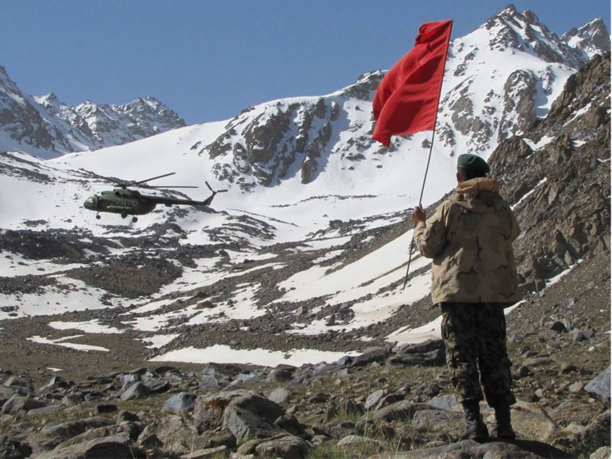 An Afghan National Army soldier signals an Afghan National Army Air Corps Mi-17 helicopter aircrew May 21, 2010, in Salang Pass, Afghanistan as Afghan forces land near the site of an AN-24 passenger airplane that crashed, killing all 44 passengers. ANAAC soldiers also flew in family members of the deceased to pay their respects.(U.S. Air Force photo by Tech. Sgt. Mike Tateishi/RELEASED)
