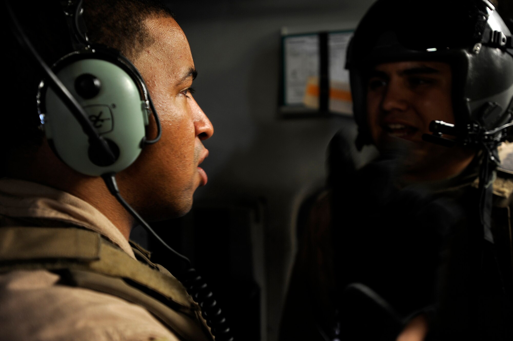 Senior Airman Kevin Johnson, left, and Senior Airman Brandon Ybarra both C-17 Globemaster III loadmasters assigned to the 816th Expeditionary Airlift Squadron, pass information during an airdrop mission, May 9, 2010, over Afghanistan. (U.S. Air Force photo/Staff Sgt. Manuel J. Martinez, released)