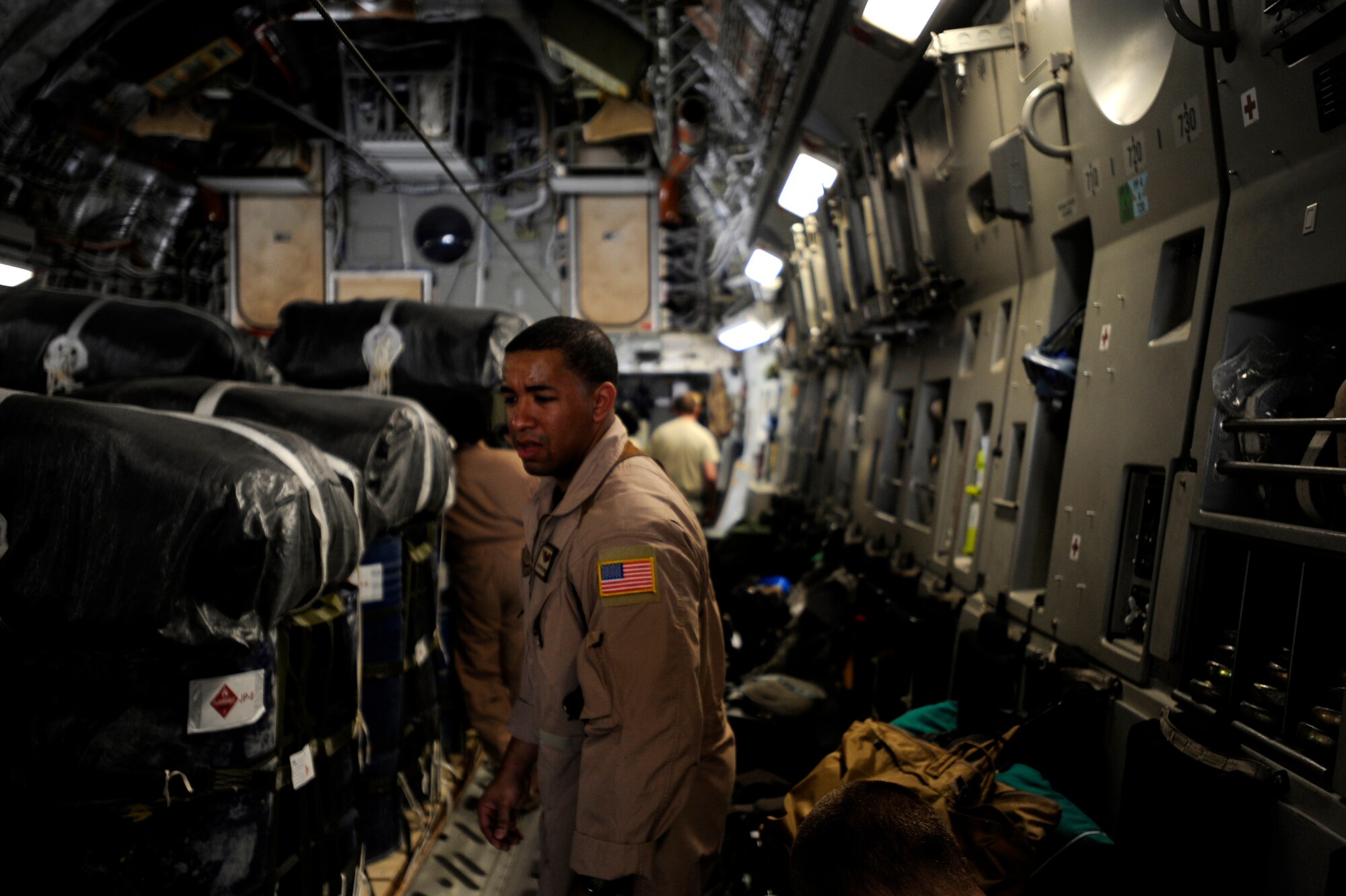 Senior Airman Kevin Johnson, a C-17 Globemaster III loadmaster assigned to the 816th Expeditionary Airlift Squadron, looks over container delivery systems before an airdrop mission, May 9, 2010, at a base in Southwest Asia. (U.S. Air Force photo/Staff Sgt. Manuel J. Martinez, released)