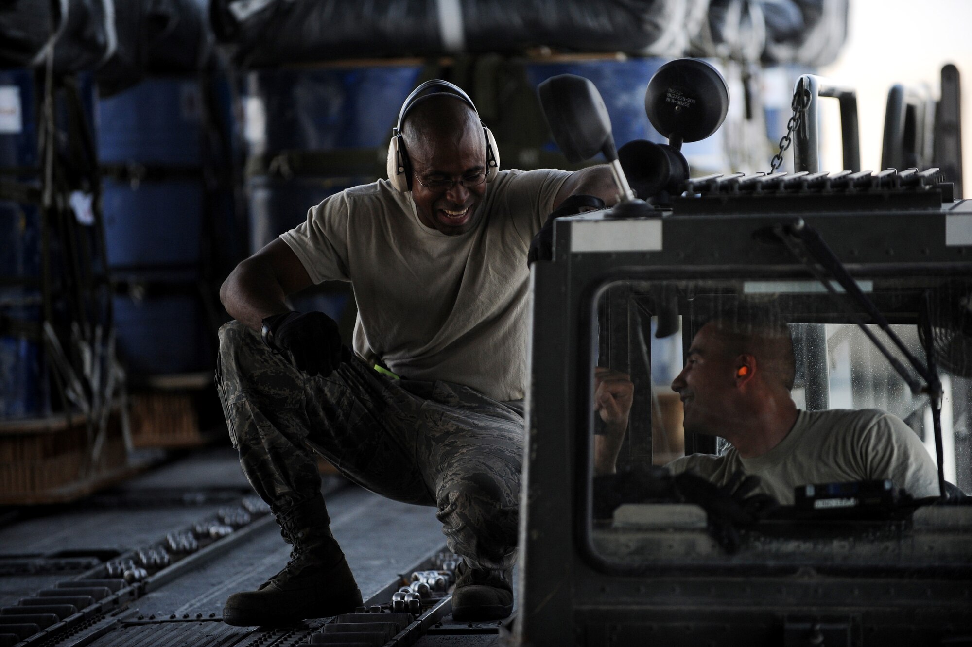 Staff Sgt. Edmund Dornelll and Senior Airman Jason Caro, both aerial porters assigned to the 8th Expeditionary Aircraft Maintenance Squadron, talk while loading container delivery systems onto a C-17 Globemaster III aircraft for an airdrop mission, May 9, 2010, at a base in Southwest Asia. (U.S. Air Force photo/Staff Sgt. Manuel J. Martinez, released)