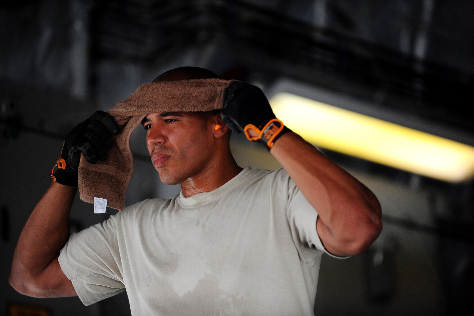 Tech. Sgt. Collin Skinner, an aerial porter assigned to the 8th Expeditionary Aircraft Maintenance Squadron, wipes sweat off his forehead while loading container delivery system bundles aboard a C-17 Globemaster III prior to an airdrop mission, May 9, 2010, at a base in Southwest Asia. (U.S. Air Force photo/Staff Sgt. Manuel J. Martinez, released)