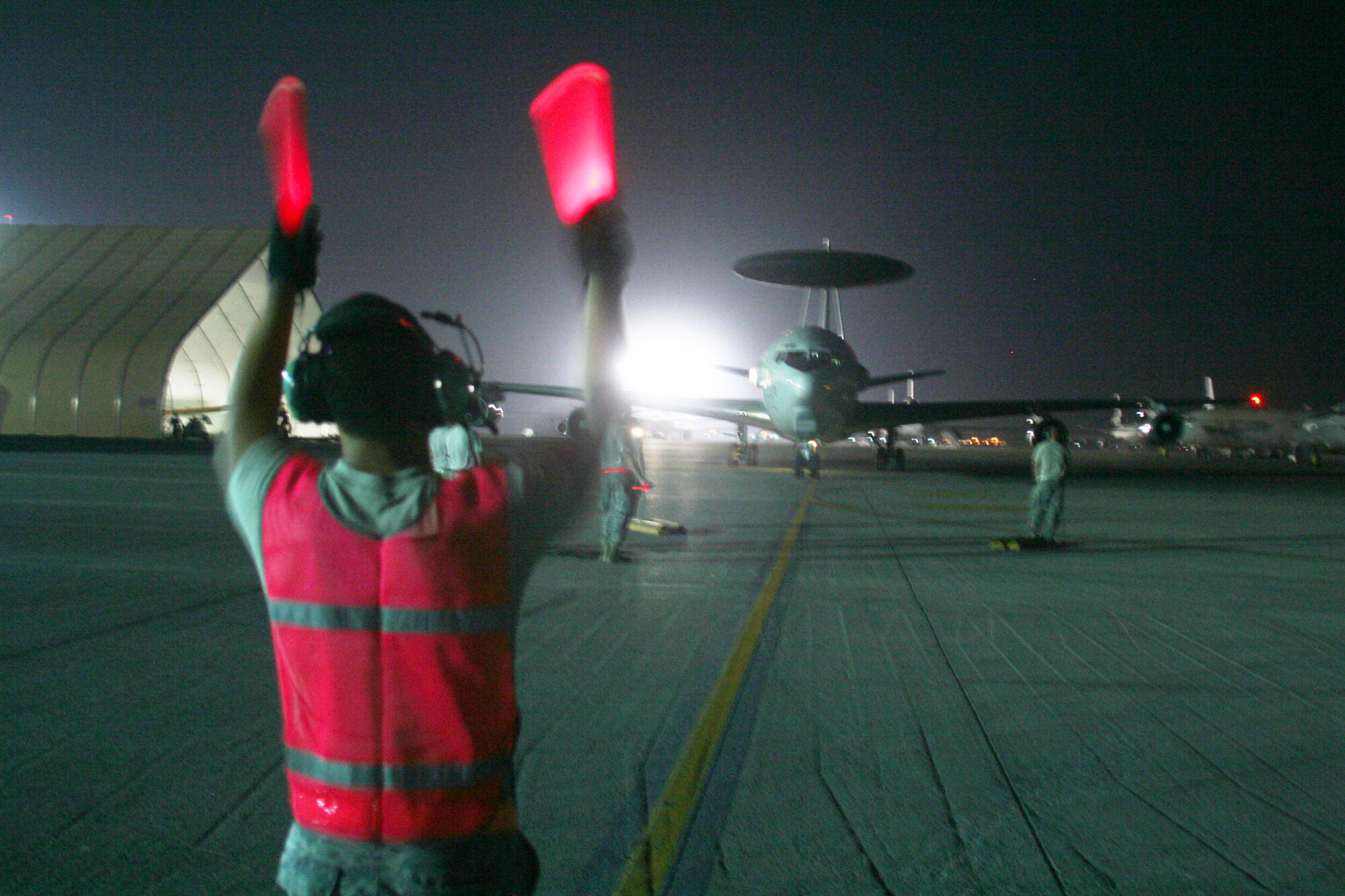 A maintenance Airman from the 380th Expeditionary Aircraft Maintenance Squadron Sentry aircraft maintenance unit uses light sticks to guide an E-3 Sentry Airborne Warning and Control System aircraft to a parking spot on the flightline during operations for the 380th Air Expeditionary Wing at a non-disclosed base in Southwest Asia on May 19, 2010. The E-3 aircraft and the Airmen who support them are deployed from the 552nd Air Control Wing at Tinker Air Force Base, Okla. (U.S. Air Force Photo/Master Sgt. Scott T. Sturkol/Released)