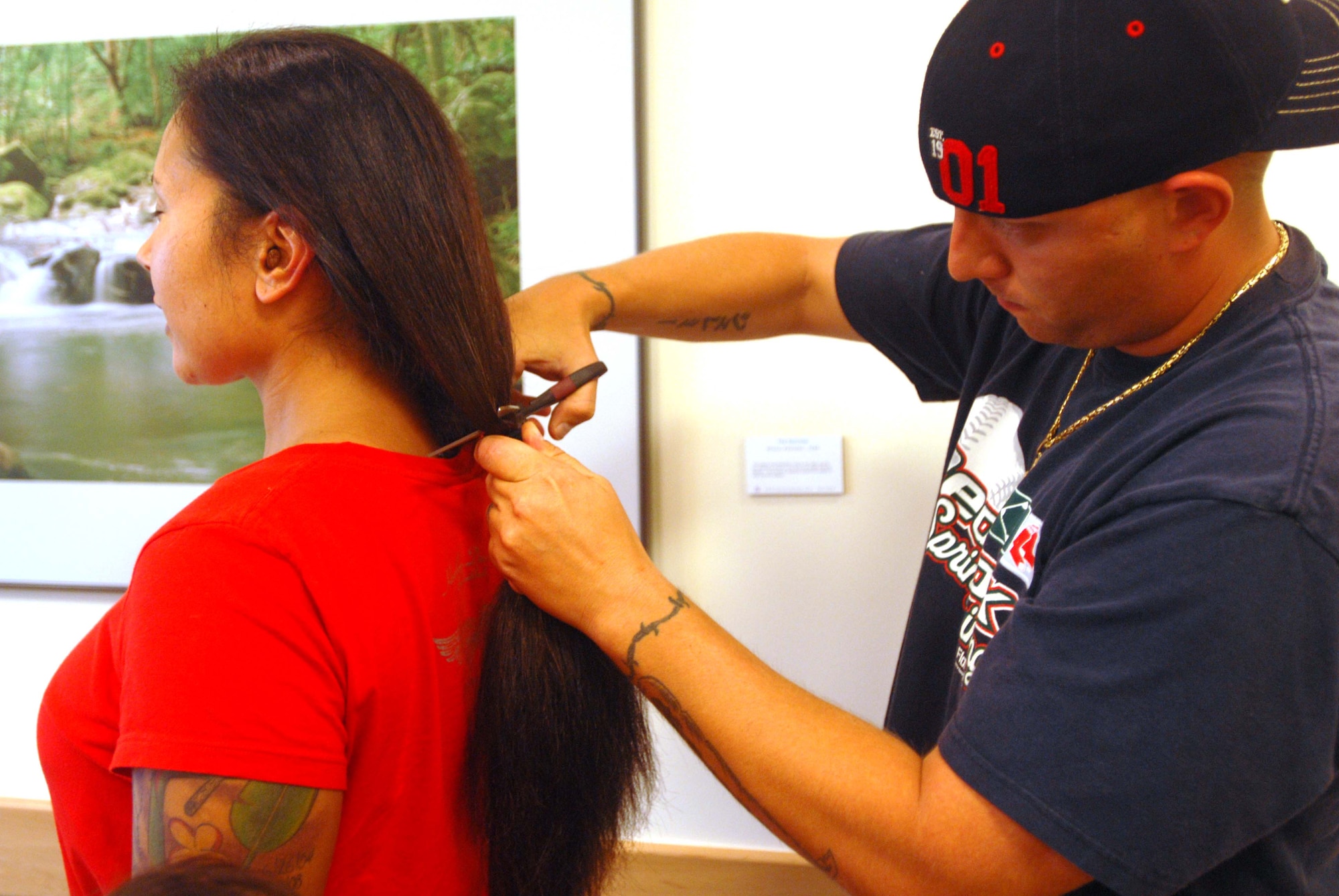 JOINT BASE PEARL HARBOR HICKAM, Hawaii – Staff Sgt. Jeremy Akerson, 15th Communications Squadron, cuts the hair of Tech. Sgt. Jenet Akerson, 692nd Intelligence, Surveillance and Reconnaissance Group Detachment 1, during the Give a Little, Give a Lock event here, May 21. All hair and money gathered through this donation is sent to Locks of Love. Locks of Love, a public non-profit organization, provides hairpieces to financially disadvantaged children in the United States and Canada under age 21 suffering from long-term medical hair loss. (U.S. Air Force photo/Senior Airman Gustavo Gonzalez)