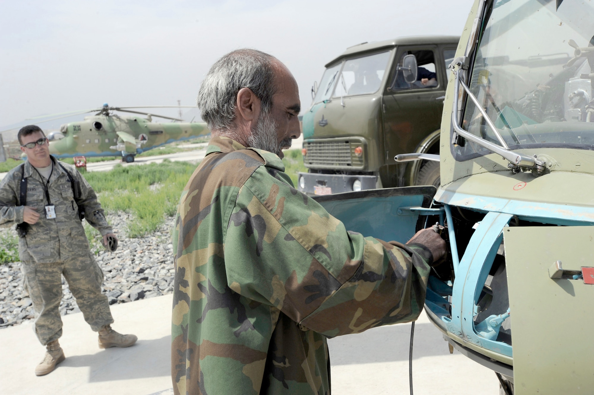 Master Sgt. Raymond Rogers Jr. watches as Aghan National Army Air Corps Lt. Amin Ullah cleans out the bullet chamber of a Yak-B Gatling gun on an MI-35 Hind E attack helicopter after a training mission May 15, 2010, at Kabul International Airport, Afghanistan. Sergeant Rogers is a 438th Air Expeditionary Advisory Squadron armament and ammunition flight adviser and Lieutenant Ullah is a weapons loader. (U.S. Air Force photo/Tech. Sgt. Oshawn Jefferson)