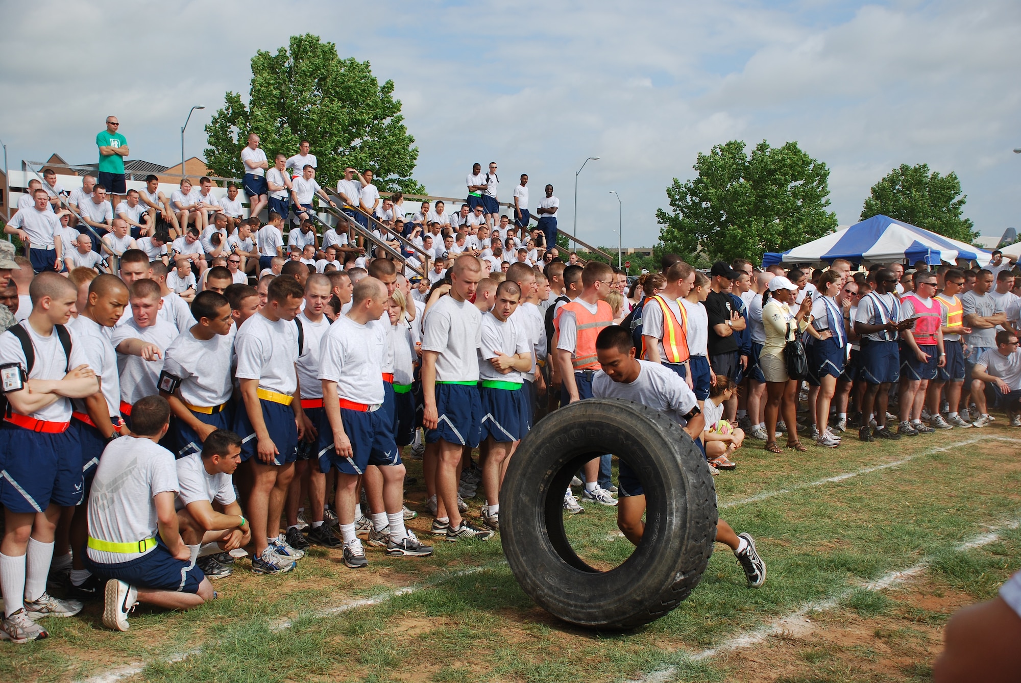 Squadrons from Team Sheppard cheer on the competitors as they compete in a tire-flipping competition to earn points for the Joint Warrior Challenge at the one-mile track May 22, 2010.  Joint Warrior Challenge was a physical competition consisting of an armor-plated relay race, a litter-carry race, a tire flipping and tug of war.  (U.S. Air Force photo/Tech. Sgt. Vernon Cunningham)