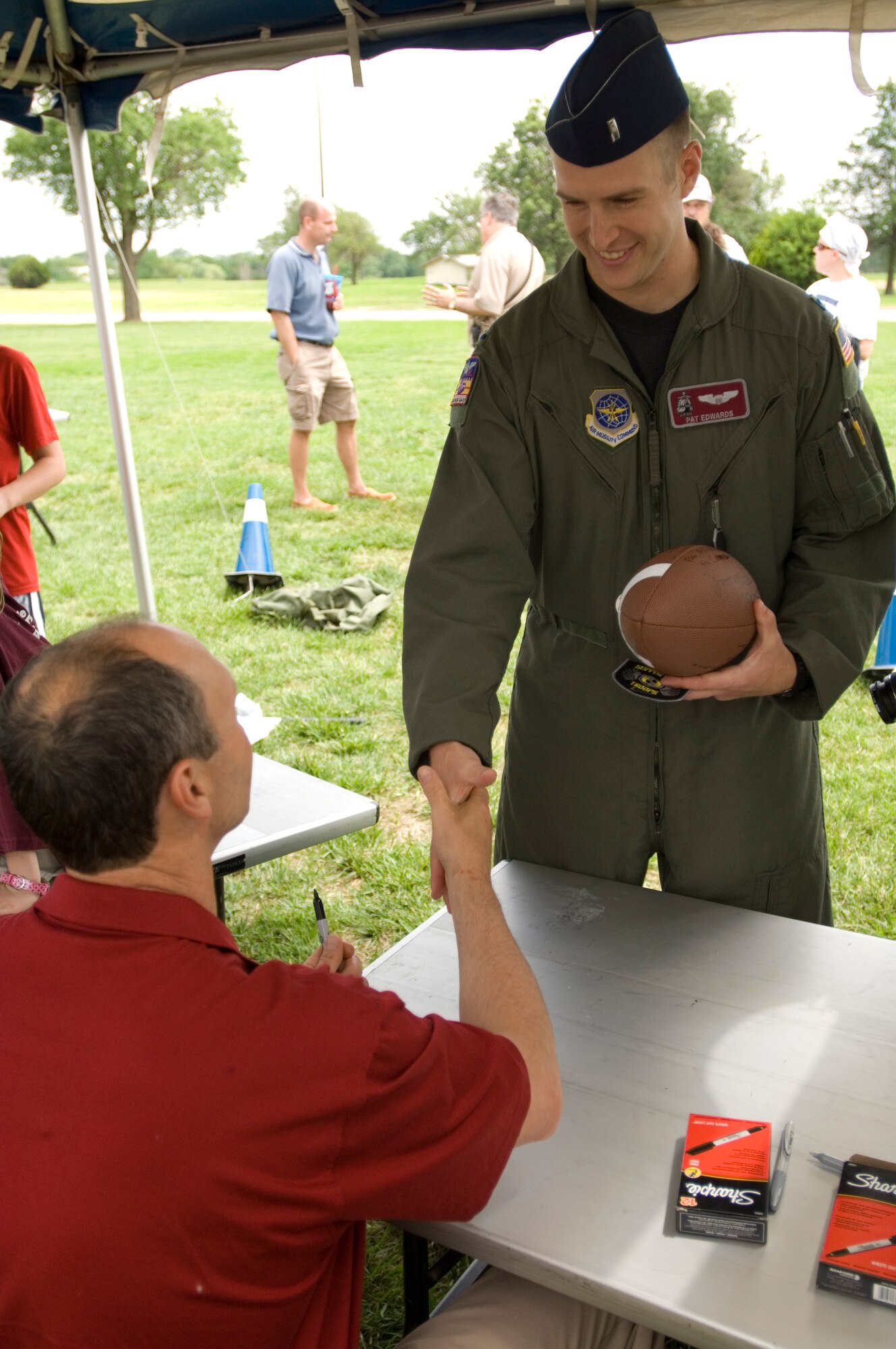 First Lt. Pat Edwards, 384th Air Refueling Squadron pilot, greets Coach Tim Murphy, Harvard University, before asking for an autograph at the Krueger Recreational Area May 22, 2010, NCAA McConnell Air Force Base, Kan. McConnell kicked off the 2010 Coaches Tour with a 5K run, a burger burn, autograph session and a flag football game. This is the third time McConnell has hosted the tour, a tour that will visit servicemembers in Europe and Southwest Asia. (U.S. Air Force photo/Airman Armando A. Schwier-Morales)