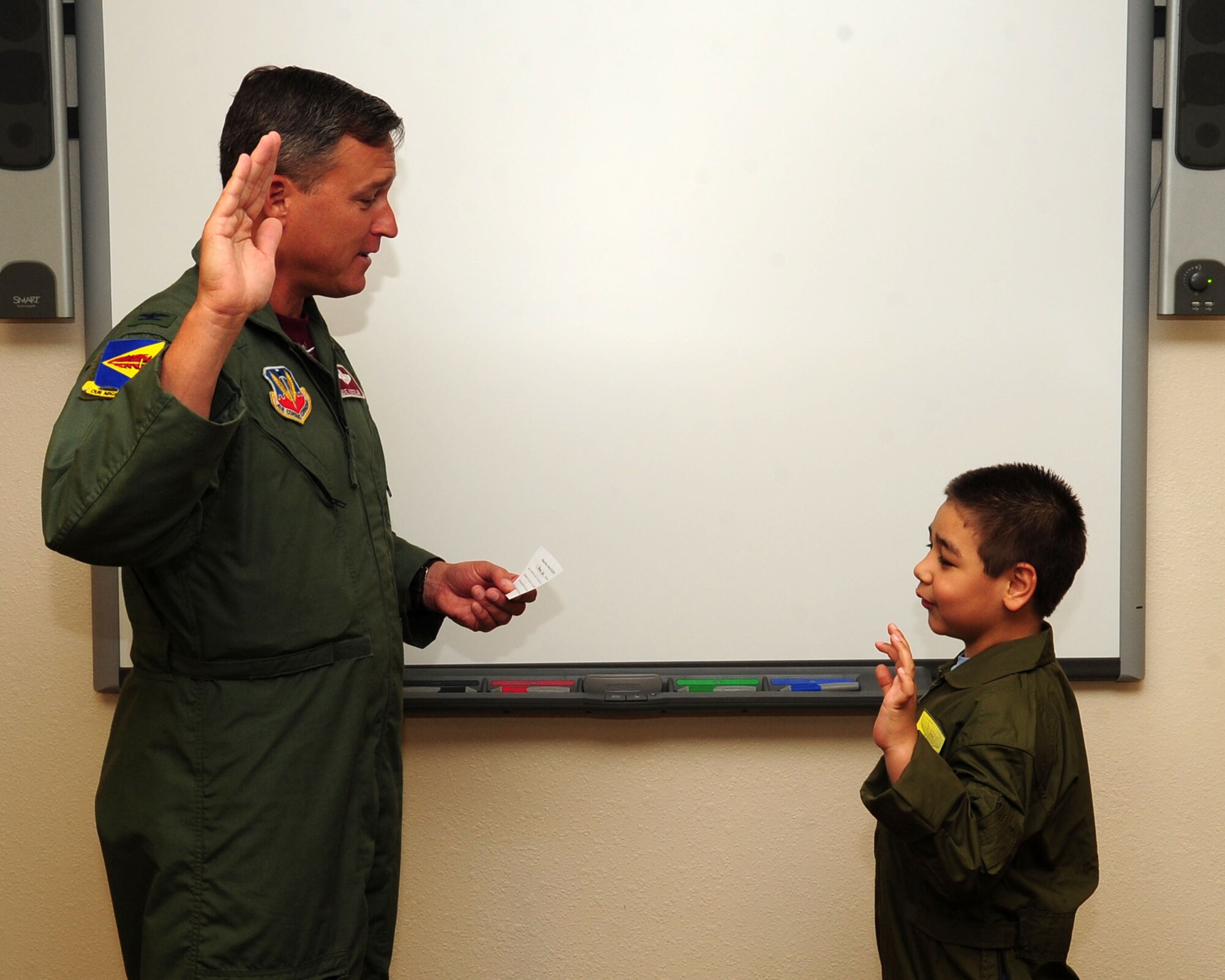 Col. Edward Kostelnik, 355th Operations Group commander, administers the Pilot for a Day oath to eight-year-old Nathan Hoffmann during the Pilot for a Day tour here May 21. The Pilot for a Day program is designed to help children with disabilities or serious illnesses enjoy a day focused on them and their interest in aviation. Nathan had a chance to fly in an A-10 simulator, see the base's fire department, aircraft static displays and meet members of the U.S. Air Force. (U.S. Air Force/Airman Jerilyn Quintanilla)

