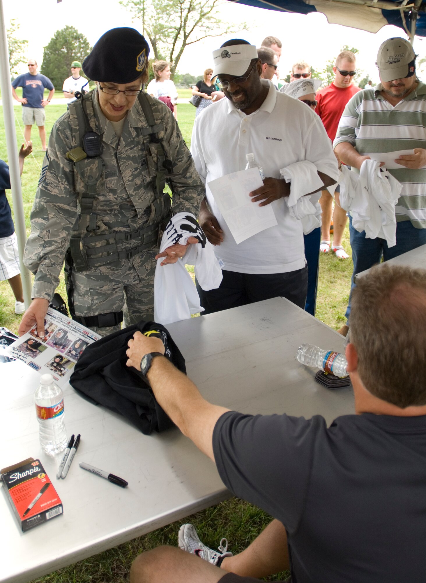 Master Sgt. Mary Casey, 22nd Security Forces Squadron flight chief, obtains an autograph from Coach Chip Kelly, University of Oregon, at the Krueger Recreational Area May 22, 2010, McConnell Air Force Base, Kan. McConnell was the first stop in the 2010 NCAA Coaches Tour, which will visit military bases in Europe and Southwest Asia. This is the third time McConnell has hosted the tour. (U.S. Air Force photo/Airman Armando A. Schwier-Morales)
