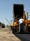 MINOT AIR FORCE BASE, N.D. – Contractor Brad Lee stands on a paver in the J.R. Rockers parking lot here May 20.  Lee is working with the 5th Civil Engineer Squadron on an overhaul project of the parking lot.  This is just one of many construction projects on base this summer.  (U.S. Air Force photo by Staff Sgt. Miguel Lara III)