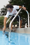 Jo Martinez, Randolph Air Force Base lifeguard, cleans around the pool deck during preparation for the 2010 swimming season. (U.S. Air Force photo/Steve Thurow)
