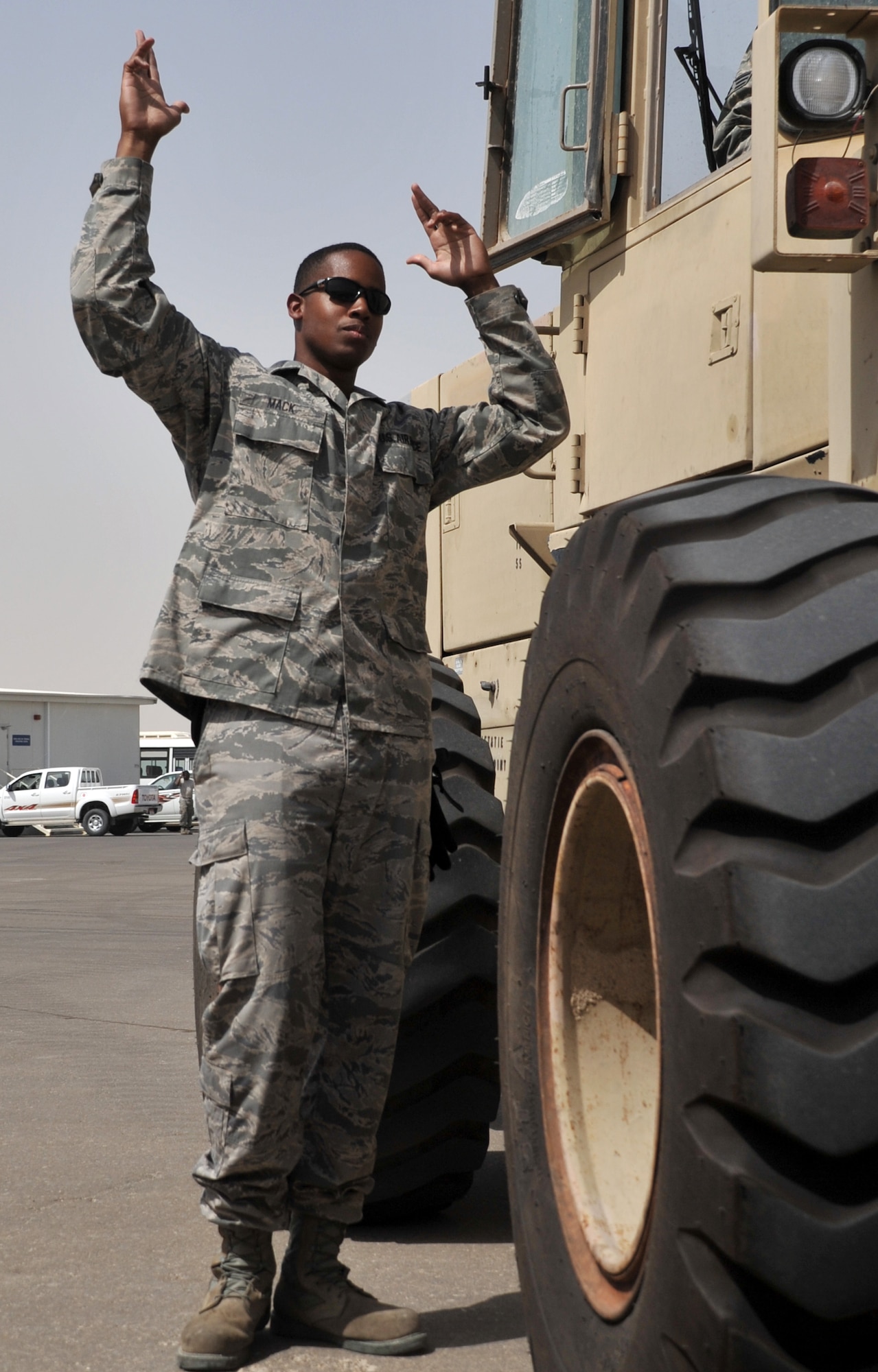 Senior Airman Julien Mack, air transportation journeyman with the 380th Expeditionary Logistics Readiness Squadron's Air Terminal Operations Center, guides the driver of an extreme terrain forklift to a cargo drop-off spot during operations at the center at a non-disclosed base in Southwest Asia on May 19, 2010. Airman Mack is deployed from the 89th Aerial Port Squadron at Joint Base Andrews, Md., and his hometown is Queens, N.Y. (U.S. Air Force Photo/Master Sgt. Scott T. Sturkol/Released)