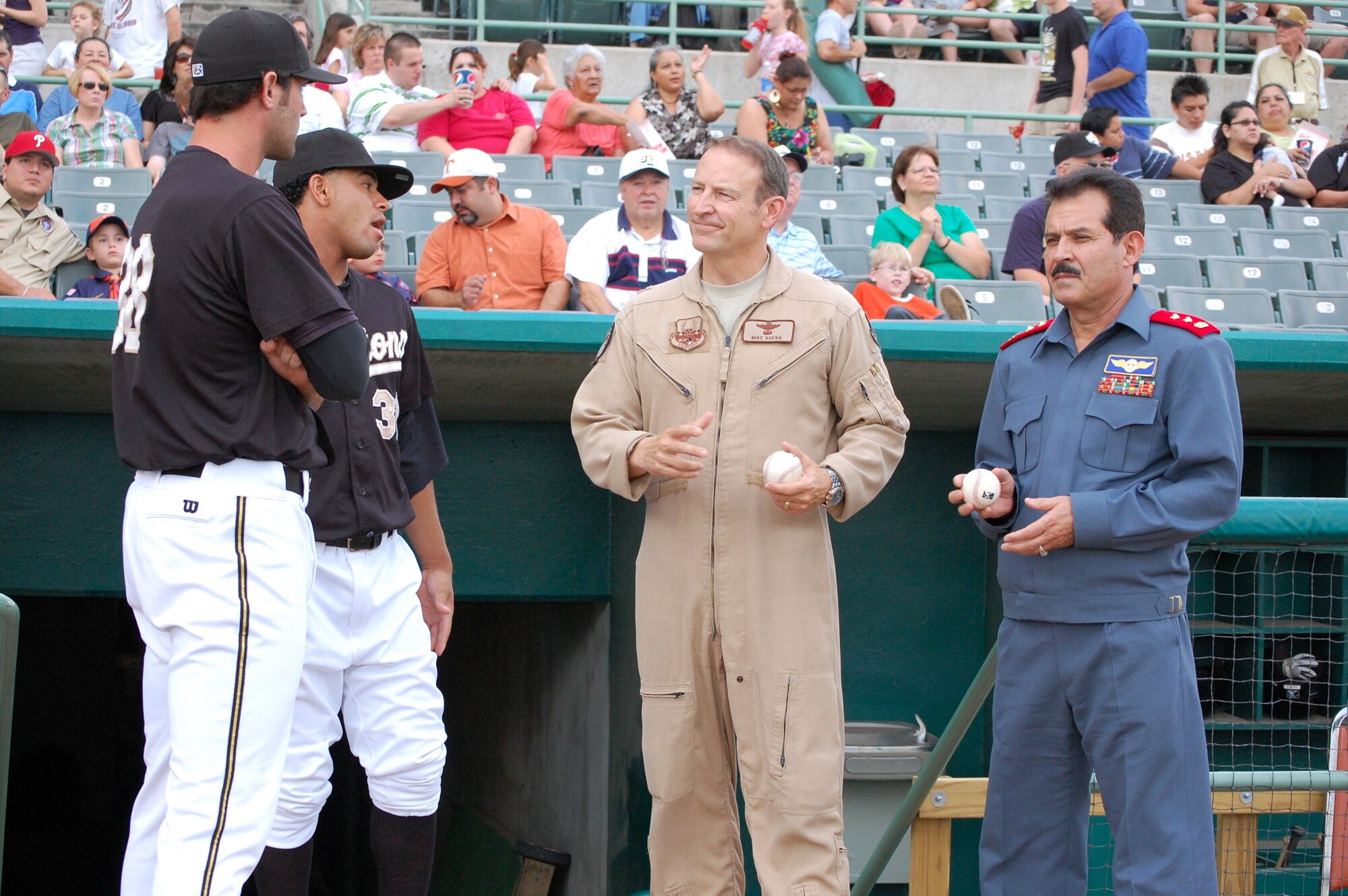 Brig. Gen. Michael Boera, Coalition Air Power Transition Force commanding general, center, and Maj. Gen. Mohammad Dawran, Afghan National army air corps, right, talk to players from the San Antonio Missions Baseball team May 23 before throwing out a dual-first pitch of the game at Wolf Stadium in San Antonio, Texas. General Dawran is visiting Air Education and Training Command to receive updated information on current and future security assistance and cooperation training for the ANAAC. General Boera is working to stand up a robust ANAAC center of excellence and he is exploring more in-depth maintenance training between the two nations. Since the establishment of the Kabul Air Corps Training Center in 2007, in Afghanistan, more than 1,100 Afghani military members have received training in air corps orientation, air traffic control, fire fighting, aircraft maintenance, loadmaster duties and gunner training. (U.S. Air Force photo/Master Sgt. Paul Kilgallon)