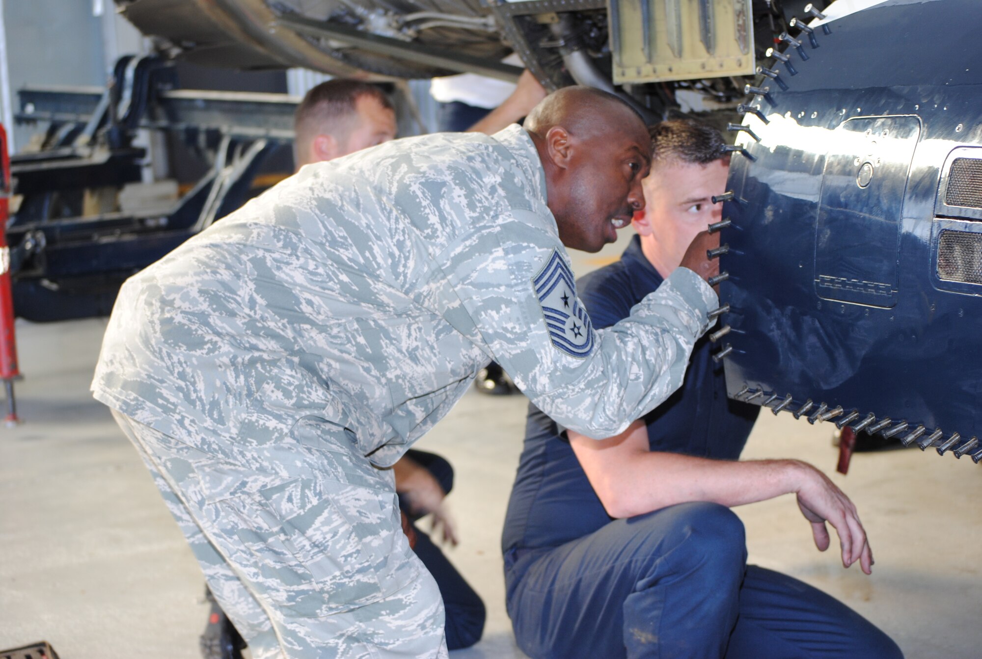 Command Chief Master Sgt. Zefrem Smith, 14th Flying Training Wing, listens as Tech. Sgt. Joseph Michel, Thunderbirds Engine Maintenance specialist, explains how the F100-PW-229 engine is removed from the Thunderbirds F-16 aircraft. (U.S. Air Force photo/Sonic Johnson).