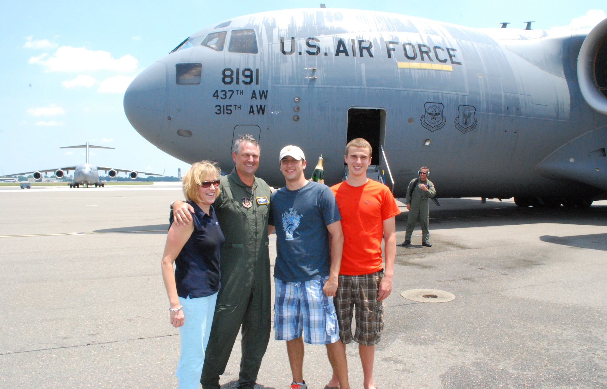 Colonel Mike Speer and family pose infront of a C-17 after his Fini Flight on Friday, May 21st.  Mrs. Barb Speer (spouse) enjoyed taxiing in Colonel Speer at the end of his Fini Flight.  Mike Speer Jr. (left) and Andrew Speer got the pleasure of spraying their father as he exited the plane.