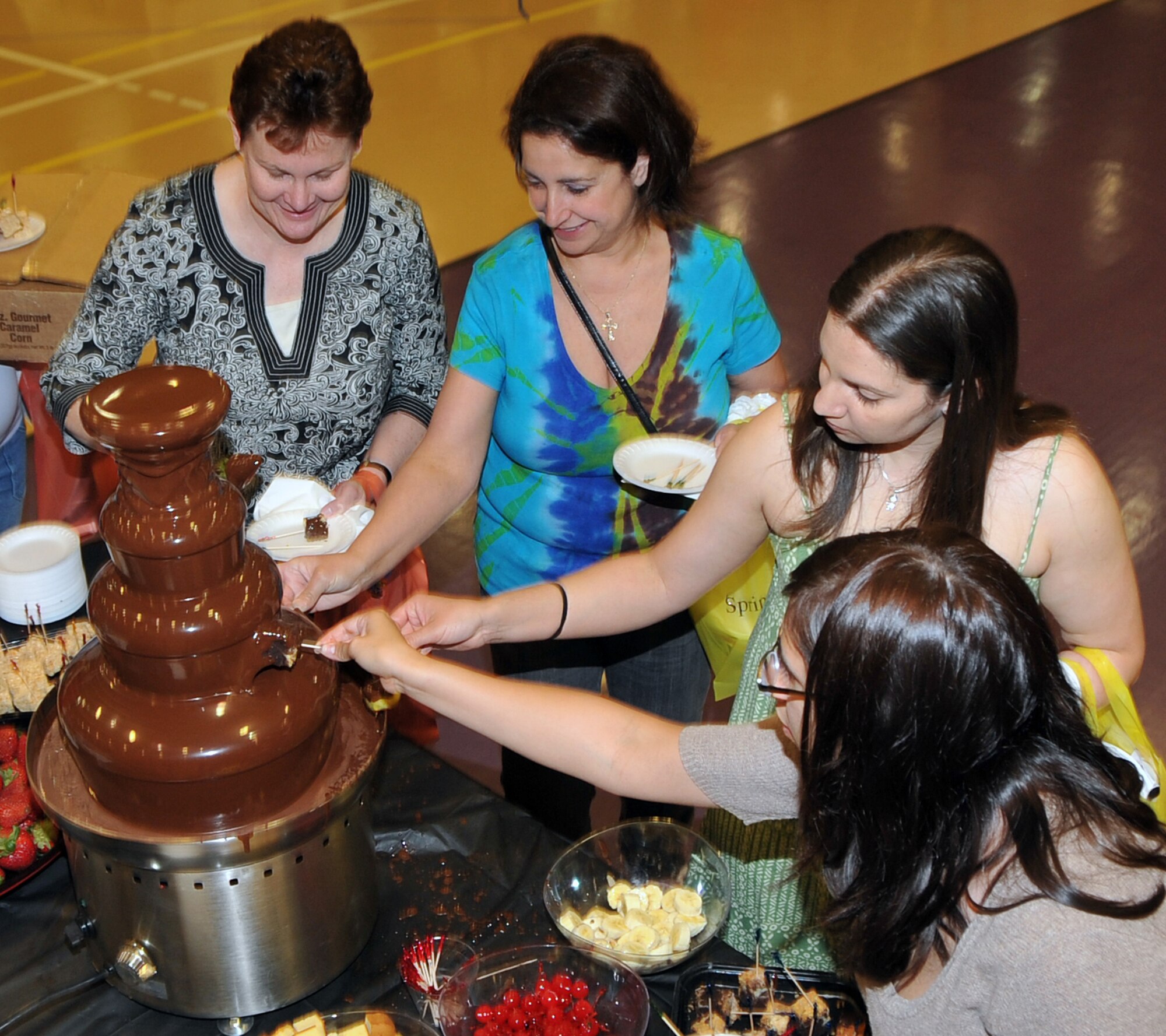 OFFUTT AIR FORCE BASE, Neb. -- Several women enjoy the taste of chocolate strawberries during the Annual Spring Spa for Spouses event at the Lied Activity Center May 19 in Bellevue, Neb. During the event, spouses of military members received free gifts, massages, manicures and dinner. U.S. Air Force Photo by Jeff W. Gates