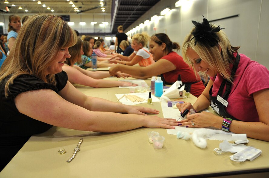 OFFUTT AIR FORCE BASE, Neb. -- Michell Moore, spouse of Tech. Sgt. Jason Moore from the 55th Security Forces Squadron, has her fingernails painted by April Martin, from the Xenon International Academy, during the Annual Spring Spa for Spouses event May 19 at the Lied Activity Center in Bellevue, Neb. During the event, spouses of military members received free gifts, massages, manicures and dinner. U.S. Air Force Photo by Jeff W. Gates 