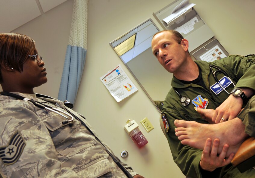MOODY AIR FORCE BASE, Ga. -- Tech. Sgt. Monica Johnson, 74th Fighter Squadron independent duty medical technician, receives training during an acute patient visit from Capt. Christopher Tana, 74th FS flight surgeon, here May 10. Captain Tana is showing her how to evaluate an ankle injury. (U.S. Air Force photo by Staff Sgt. Schelli Jones/RELEASED)