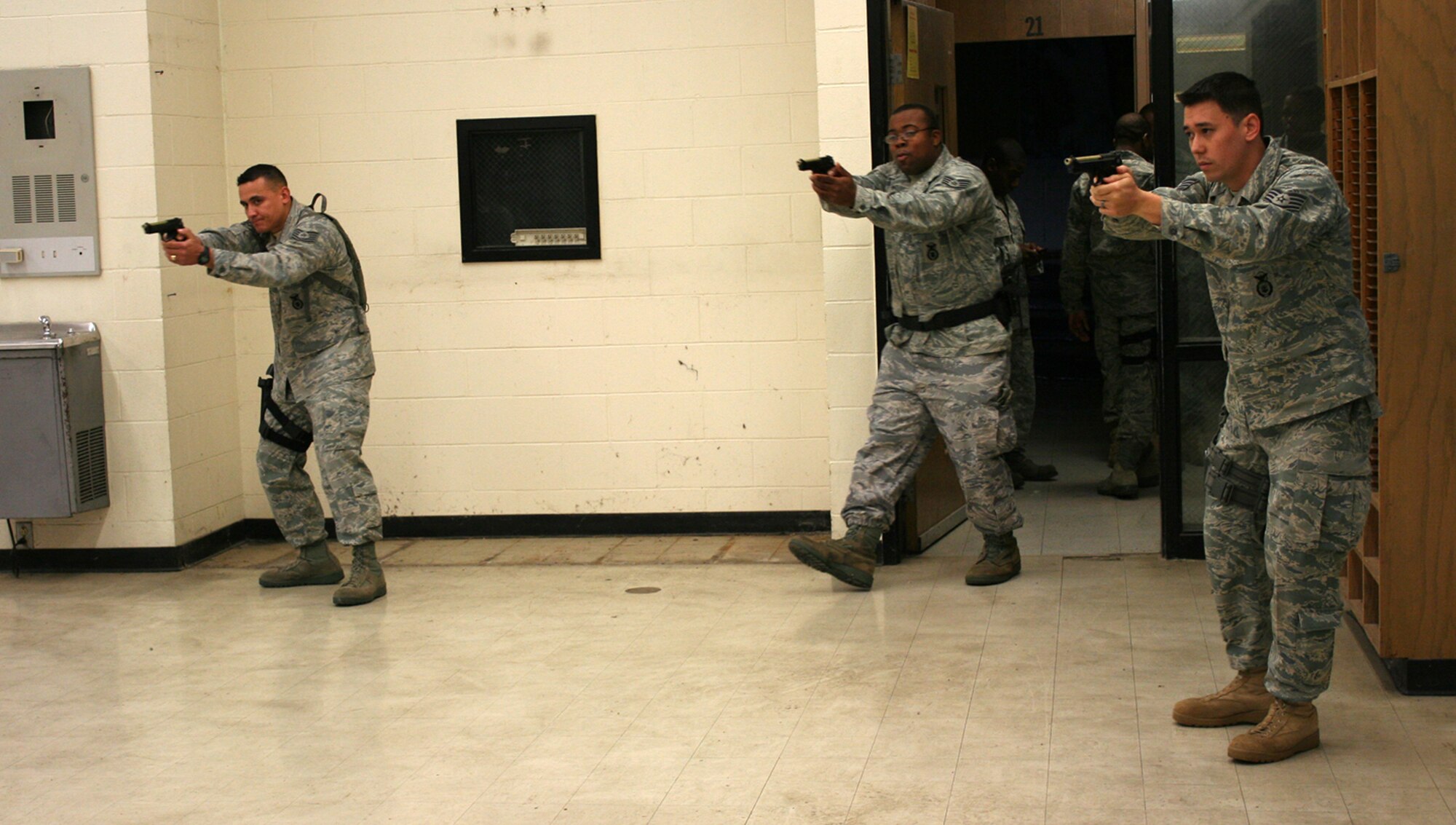 WRIGHT-PATTERSON AIR FORCE BASE, Ohio -- Tech. Sgt. Siam Siripavaket (left) and Staff Sgt. Zach Johnson (right), 445th Security Forces Squadron, simulate securing a room with Staff Sgt. Lamarcus Penn (center), 88th Security Forces Squadron, during training May 20 in Columbus, Ohio.  The Active Shooter Training Course was taught by the Ohio State Highway Patrol Special Response Team, which has provided similar training to more than 6,000 law enforcement and peace officers throughout the state, including Airmen from the 88th Security Forces Squadron.  It was the first time Airmen from the 445th Airlift Wing attended the training.  (U.S. Air Force photo/Capt. Caroline Wellman)