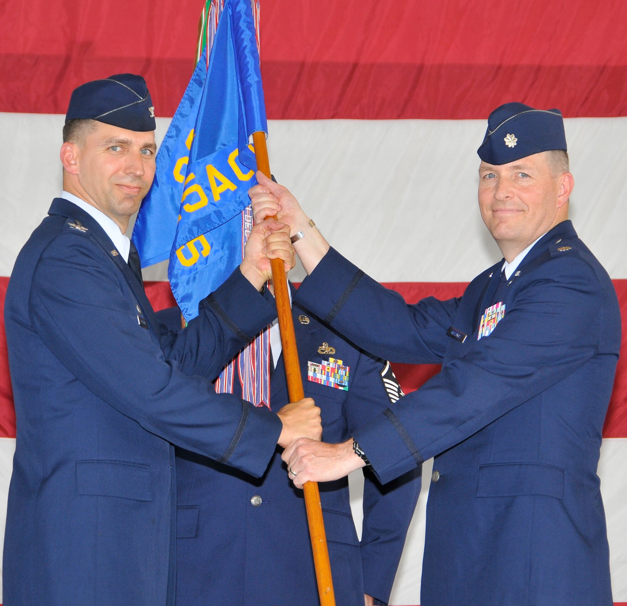 Lt. Col. Robert Grazulis receives the 325th Air Control Squadron guidon from Col. Wesley Hallman, 325th Operations Group commander, during a change of command ceremony May 21 in Hangar 2.   Colonel Grazulis takes command of the 325th ACS after being former director of operations at the squadron (U.S. Air Force photo by Lisa Norman)