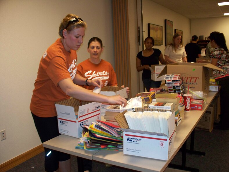 HOLLOMAN AIR FORCE BASE, N.M. -- Members of Team Holloman package items into boxes to be shipped to deployed troops during Operation Care Package May 11, 2010. The volunteers who participated in the packing party represented numerous groups to include First Sergeants, Key Spouses, Airman & Family Readiness Center Staff, Airmen from various base organizations and many more. Volunteers put together 385 care packages to be sent down range. (Courtesy photo / Released)