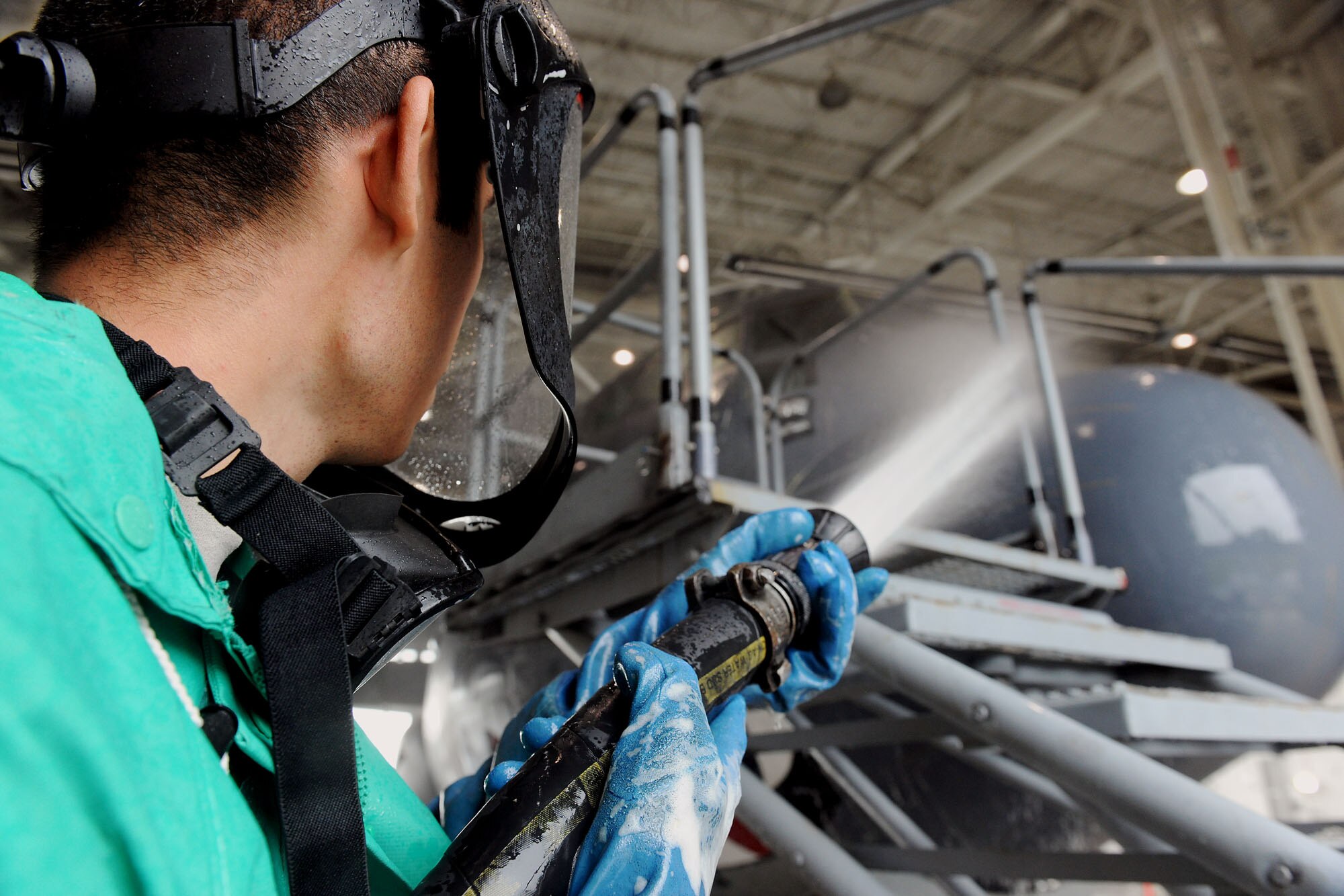 MOODY AIR FORCE BASE, Ga. -- Airman 1st Class Gorge Rodriguez, 23rd Equipment Maintenance Squadron aerospace propulsion apprentice, rinses the soap cleaner off of a HC-130P Combat King here May 17. While washing the C-130, Airmen are required to take preventive steps by wearing proper protective gear because of a chemical-based washing liquid used to wash the aircraft. (U.S. Air Force photo by Airman 1st Class Joshua Green/RELEASED)