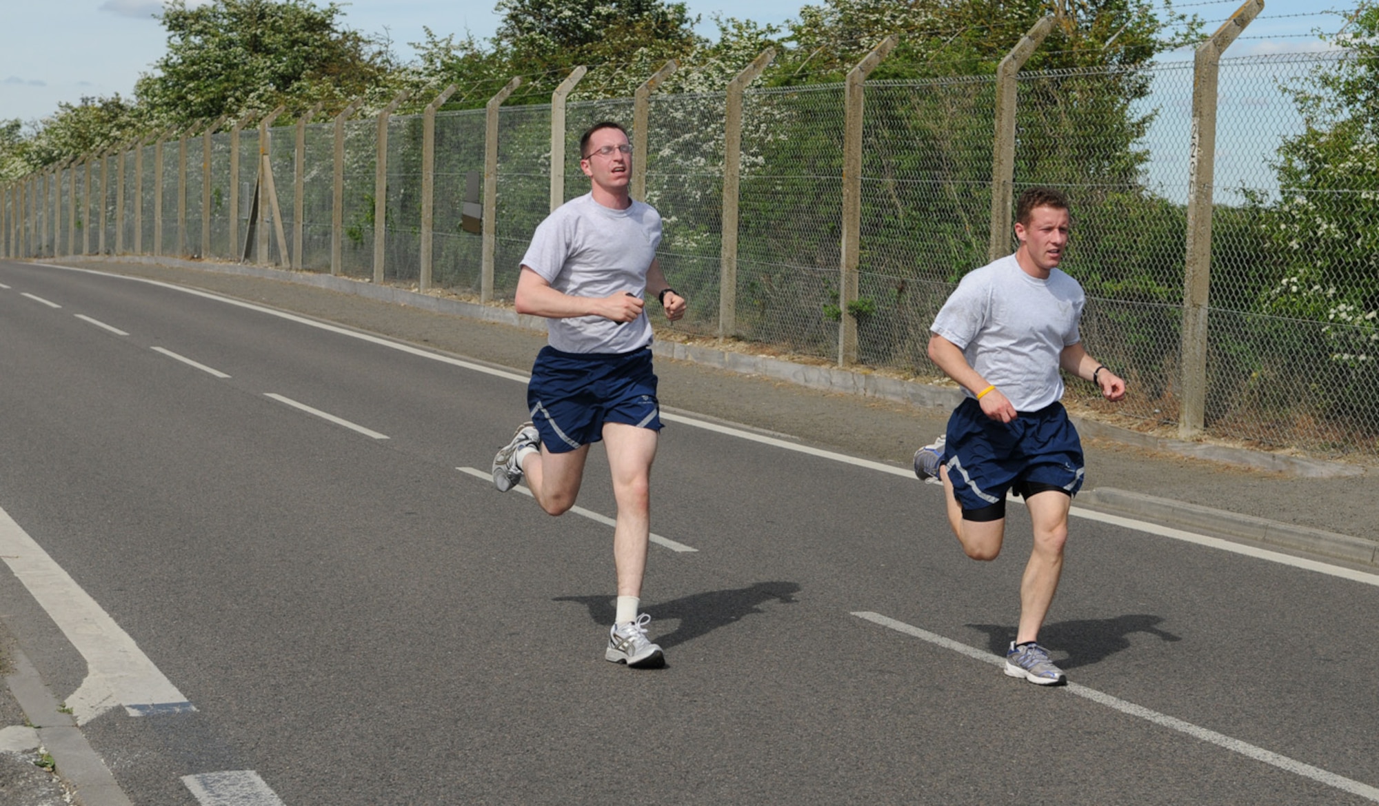 Airman 1st Class Jon Porubsky, right, and Capt. Nicholas Brence, both 100th Security Forces Squadron, were the first pair across the finish line. Airmen had to run and finish the event with a wingman. The two 100th SFS members crossed the finish line in 18 minutes, 33 seconds. (U.S. Air Force photo/Karen Abeyasekere)