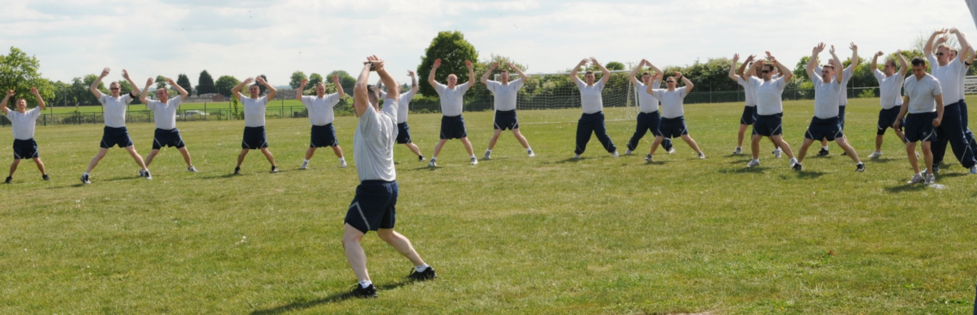 Members from the 100th Maintenance Squadron warm up in preparation for the 100th Air Refueling Wing 5K Fun Run May 21. Tech. Sgt. Justice Rogers, center, put his fellow squadron members through their paces before the start of the run. (U.S. Air Force photo/Karen Abeyasekere)