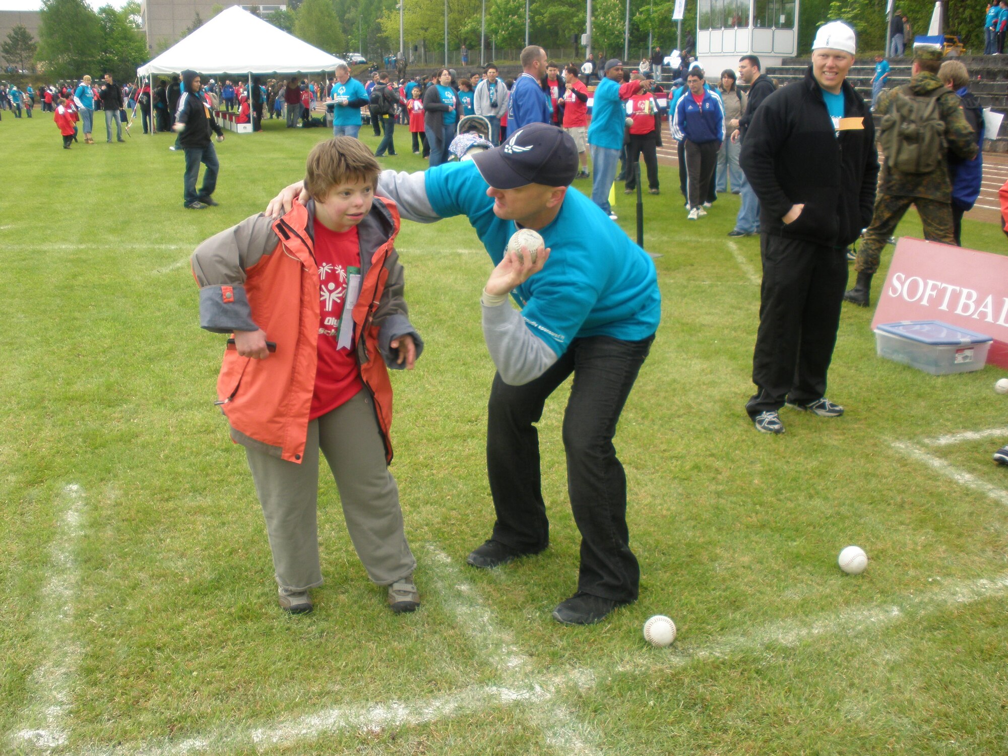 KAISERSLAUTERN, Germany – Master Sgt. Brian Rogers, 726th Air Mobility Squadron, demonstrates the proper technique in throwing a softball to a participant in the Special Olympics Day May 12 in Kaiserslautern, Germany. Sergeant Rogers volunteered along with other member of Spangdahlem’s local Airlift Tanker Association chapter, the Halvorson Chapter. (U.S. Air Force photo/Shari Sims)