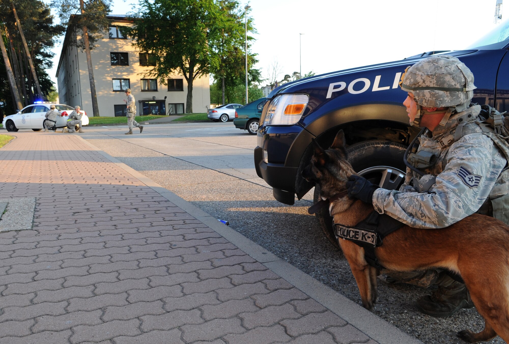 U.S. Air Force Staff Sgt. Daren Marshall, 86th Security Forces Squadron K-9 handler, and Olivia, military working dog, prepare to search a building during an Operational Readiness Exercise (ORE), Ramstein Air Base, Germany, May 23, 2010. An ORE incorporates a series of events that evaluate a wing's ability to perform accurately in a timely manner. (U.S. Air Force Photo by Airman 1st Class Caleb Pierce)