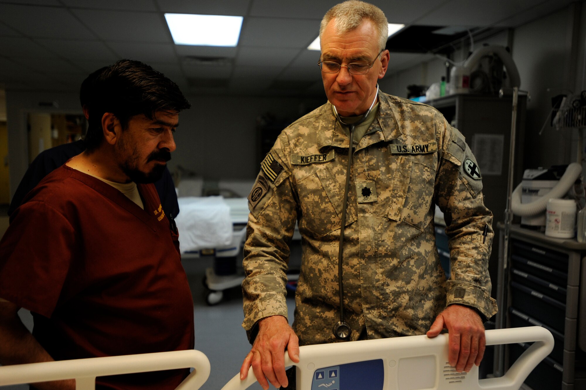 Army Lt. Col.(Dr.) Bob Kieffer, right, a vascular surgeon assigned to the 452nd Combat Support Hospital, speaks with an Afghan doctor about a Afghan man they are assessing, May 12, 2010, at the Forward Operating Base Salerno Hospital, Afghanistan. (U.S. Air Force photo/Staff Sgt. Manuel J. Martinez/released) 