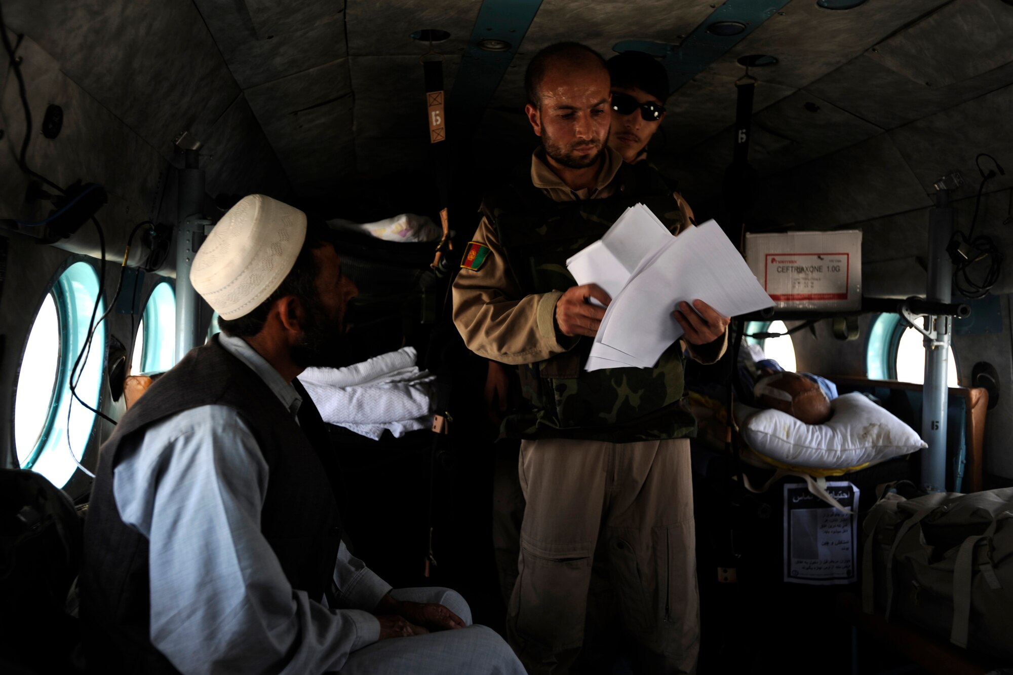 Sergeant Malik Hamet, an Afghan National Army Air Corps flight medic, speaks with the father of an Afghan boy aboard an Mi-17 helicopter during a reverse medical evacuation May 12, 2010, over Afghanistan. (U.S. Air Force photo/Staff Sgt. Manuel J. Martinez/released) 