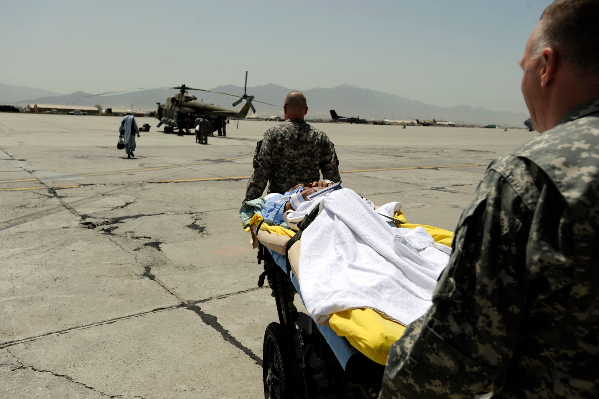 U.S. Army Specialist Steven Copt, right, and Sgt. Marvin Andelin, both medics assigned to the 144th Area Support Medical Company, take an Afghan man to an Mi-17 helicopter after he was treated and discharged from the Craig Joint Theater Hospital May 12, 2010, at Bagram Airfield, Afghanistan. (U.S. Air Force photo/Staff Sgt. Manuel J. Martinez/released) 