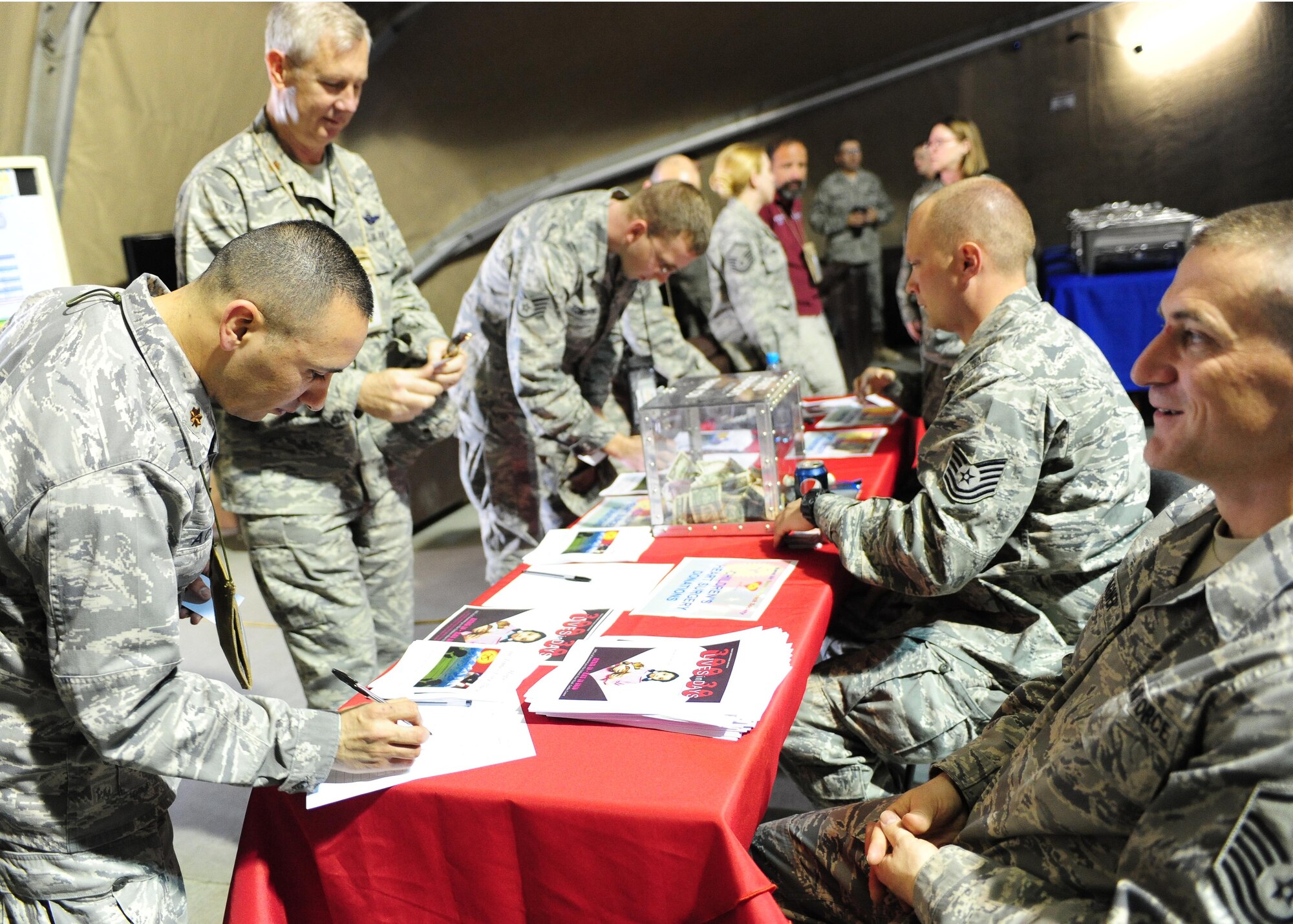 Airmen at the Transit Center at Manas, Kyrgyzstan, fill out pledge forms for the ?300 Lives in 30 Days? fundraiser, which resulted in $50,000 for the children?s heart surgery fund ? enough to fund almost 90 more surgeries for children. (U.S. Air Force photo/Senior Airman Nichelle Anderson/ released)